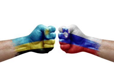 Two hands punch to each others on white background. Country flags painted fists, conflict crisis concept between rwanda and slovenia