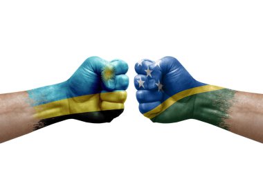 Two hands punch to each others on white background. Country flags painted fists, conflict crisis concept between rwanda and solomon islands