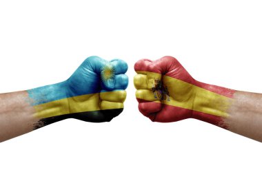Two hands punch to each others on white background. Country flags painted fists, conflict crisis concept between rwanda and spain