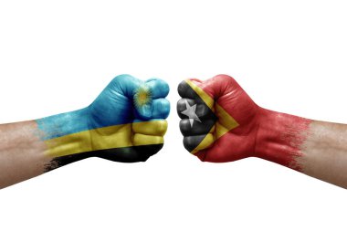 Two hands punch to each others on white background. Country flags painted fists, conflict crisis concept between rwanda and timor leste