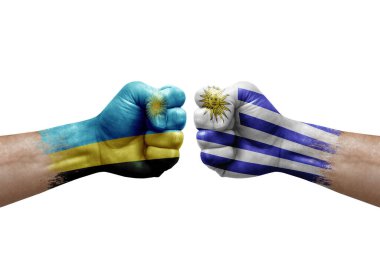 Two hands punch to each others on white background. Country flags painted fists, conflict crisis concept between rwanda and uruguay