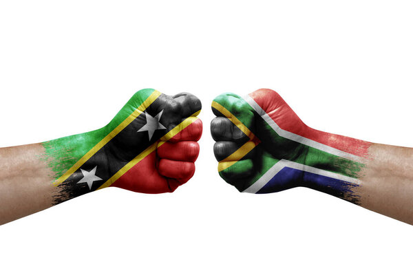 Two hands punch to each others on white background. Country flags painted fists, conflict crisis concept between saint kitts and nevis and south africa