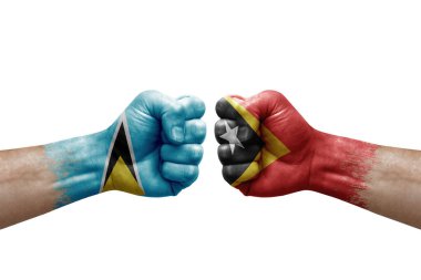 Two hands punch to each others on white background. Country flags painted fists, conflict crisis concept between saint lucia and timor leste