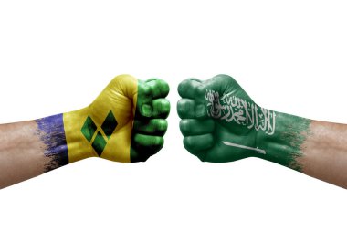 Two hands punch to each others on white background. Country flags painted fists, conflict crisis concept between saint vincent and the grenadines and saudi arabia