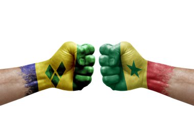 Two hands punch to each others on white background. Country flags painted fists, conflict crisis concept between saint vincent and the grenadines and senegal
