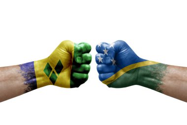 Two hands punch to each others on white background. Country flags painted fists, conflict crisis concept between saint vincent and the grenadines and solomon islands