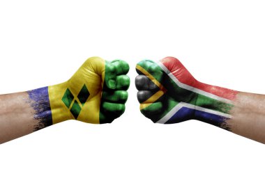 Two hands punch to each others on white background. Country flags painted fists, conflict crisis concept between saint vincent and the grenadines and south africa