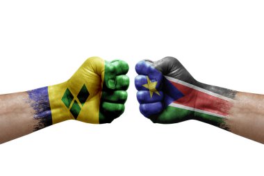 Two hands punch to each others on white background. Country flags painted fists, conflict crisis concept between saint vincent and the grenadines and south sudan