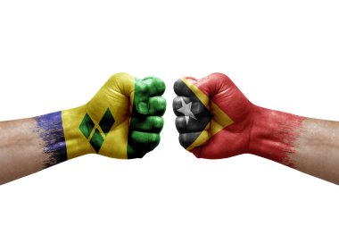 Two hands punch to each others on white background. Country flags painted fists, conflict crisis concept between saint vincent and the grenadines and timor leste
