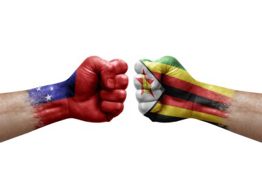 Two hands punch to each others on white background. Country flags painted fists, conflict crisis concept between samoa and zimbabwe