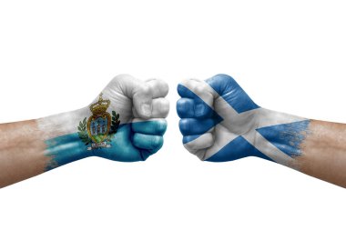 Two hands punch to each others on white background. Country flags painted fists, conflict crisis concept between san marino and scotland