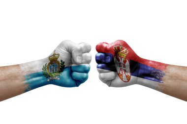 Two hands punch to each others on white background. Country flags painted fists, conflict crisis concept between san marino and serbia