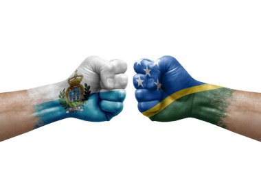 Two hands punch to each others on white background. Country flags painted fists, conflict crisis concept between san marino and solomon islands