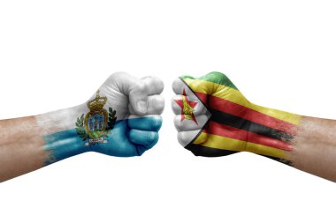 Two hands punch to each others on white background. Country flags painted fists, conflict crisis concept between san marino and zimbabwe