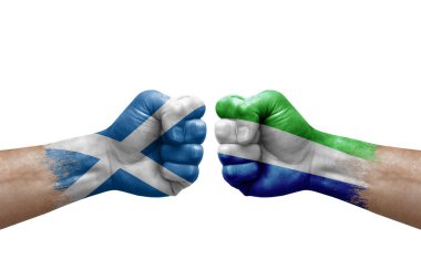 Two hands punch to each others on white background. Country flags painted fists, conflict crisis concept between scotland and sierra leone