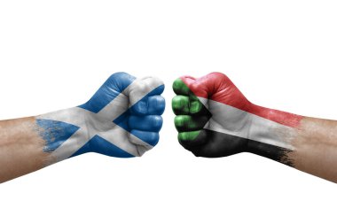 Two hands punch to each others on white background. Country flags painted fists, conflict crisis concept between scotland and sudan