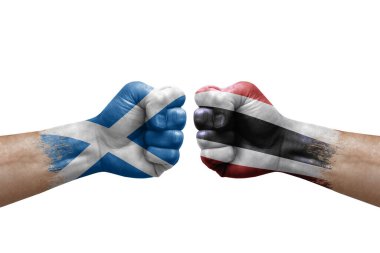 Two hands punch to each others on white background. Country flags painted fists, conflict crisis concept between scotland and thailand