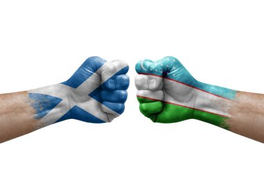 Two hands punch to each others on white background. Country flags painted fists, conflict crisis concept between scotland and uzbekistan