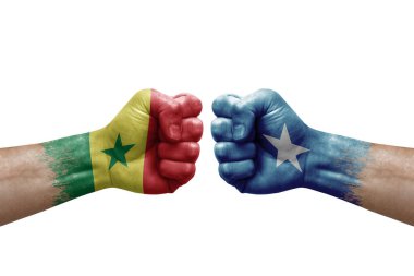 Two hands punch to each others on white background. Country flags painted fists, conflict crisis concept between senegal and somalia