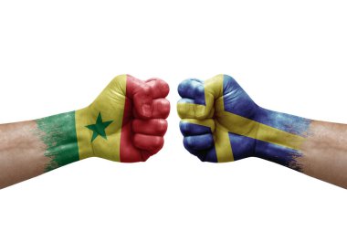 Two hands punch to each others on white background. Country flags painted fists, conflict crisis concept between senegal and sweden