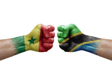 Two hands punch to each others on white background. Country flags painted fists, conflict crisis concept between senegal and tanzania