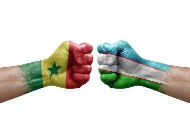 Two hands punch to each others on white background. Country flags painted fists, conflict crisis concept between senegal and uzbekistan