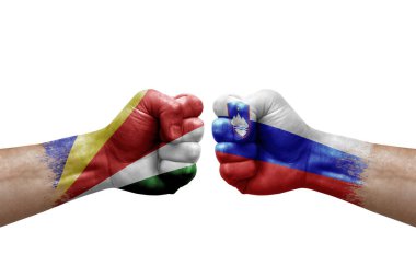 Two hands punch to each others on white background. Country flags painted fists, conflict crisis concept between seychelles and slovenia