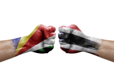 Two hands punch to each others on white background. Country flags painted fists, conflict crisis concept between seychelles and thailand