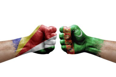 Two hands punch to each others on white background. Country flags painted fists, conflict crisis concept between seychelles and turkmenistan