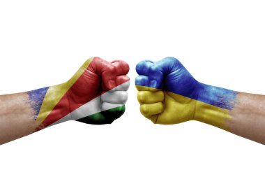 Two hands punch to each others on white background. Country flags painted fists, conflict crisis concept between seychelles and ukraine