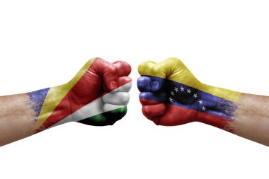 Two hands punch to each others on white background. Country flags painted fists, conflict crisis concept between seychelles and venezuela