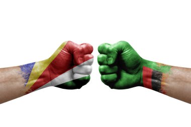 Two hands punch to each others on white background. Country flags painted fists, conflict crisis concept between seychelles and zambia