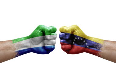 Two hands punch to each others on white background. Country flags painted fists, conflict crisis concept between sierra leone and venezuela