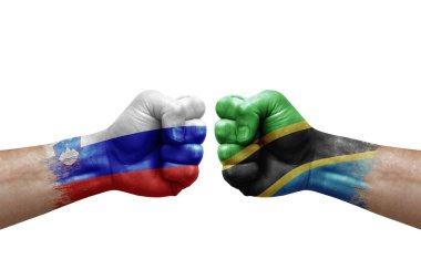 Two hands punch to each others on white background. Country flags painted fists, conflict crisis concept between slovenia and tanzania