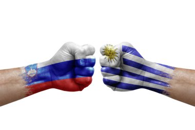 Two hands punch to each others on white background. Country flags painted fists, conflict crisis concept between slovenia and uruguay