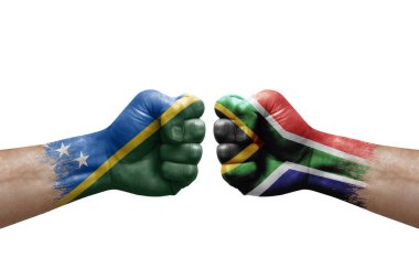 Two hands punch to each others on white background. Country flags painted fists, conflict crisis concept between solomon islands and south africa