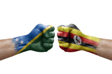 Two hands punch to each others on white background. Country flags painted fists, conflict crisis concept between solomon islands and uganda