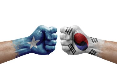 Two hands punch to each others on white background. Country flags painted fists, conflict crisis concept between somalia and south korea