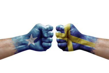 Two hands punch to each others on white background. Country flags painted fists, conflict crisis concept between somalia and sweden