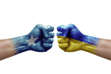 Two hands punch to each others on white background. Country flags painted fists, conflict crisis concept between somalia and ukraine