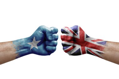 Two hands punch to each others on white background. Country flags painted fists, conflict crisis concept between somalia and united kingdom