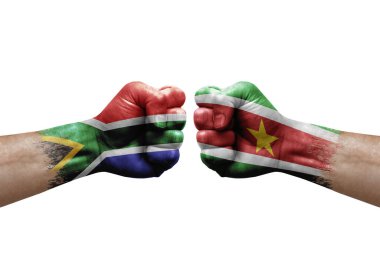 Two hands punch to each others on white background. Country flags painted fists, conflict crisis concept between south africa and suriname