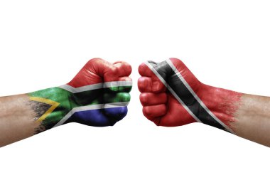 Two hands punch to each others on white background. Country flags painted fists, conflict crisis concept between south africa and tobago