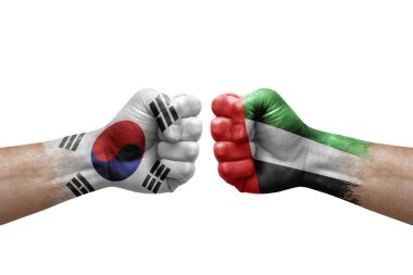 Two hands punch to each others on white background. Country flags painted fists, conflict crisis concept between south korea and united arab emirates