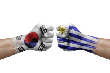 Two hands punch to each others on white background. Country flags painted fists, conflict crisis concept between south korea and uruguay