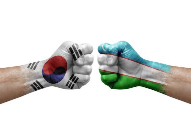 Two hands punch to each others on white background. Country flags painted fists, conflict crisis concept between south korea and uzbekistan
