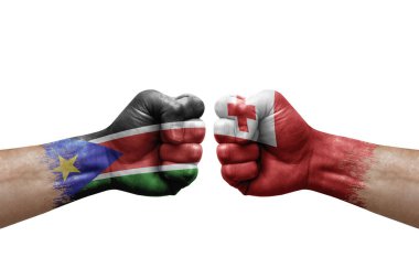 Two hands punch to each others on white background. Country flags painted fists, conflict crisis concept between south sudan and tonga