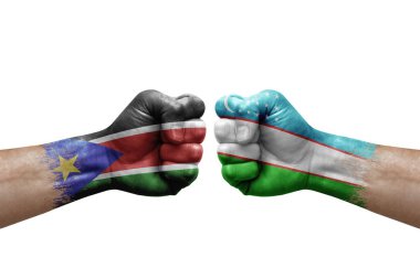 Two hands punch to each others on white background. Country flags painted fists, conflict crisis concept between south sudan and uzbekistan