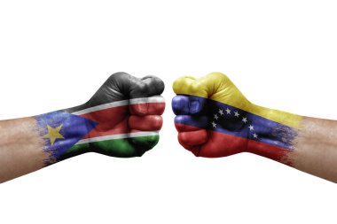 Two hands punch to each others on white background. Country flags painted fists, conflict crisis concept between south sudan and venezuela