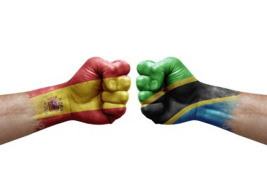 Two hands punch to each others on white background. Country flags painted fists, conflict crisis concept between spain and tanzania